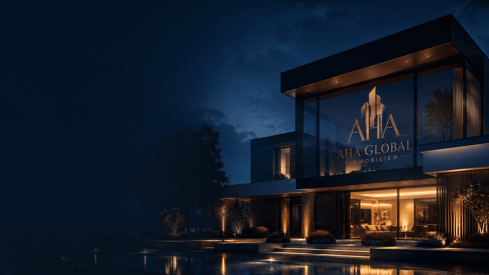 Beleuchtete Architektenvilla bei Nacht mit dem AHA Global Immobilien Schriftzug auf der Glasfassade